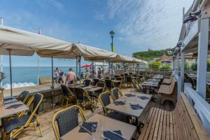 a restaurant on the beach with tables and chairs at Hotel Le Rayon Vert in Étretat