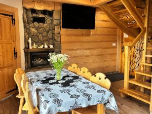 a dining room with a table and a fireplace at Witowianskie Domki Private Jacuzzi & Mountain View near Zakopane in Dzianisz