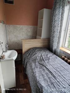 una piccola camera con letto e lavandino di своя комната в трёхкомнатной квартире или квартира целиком a Maardu