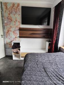 una camera con letto e TV a parete di своя комната в трёхкомнатной квартире или квартира целиком a Maardu