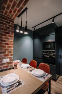 a dining room with a table with chairs and a microwave at Karma Chic&Style Intera Villa in Korçë