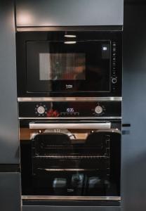 a black microwave oven sitting inside of a kitchen at Karma Chic&Style Intera Villa in Korçë