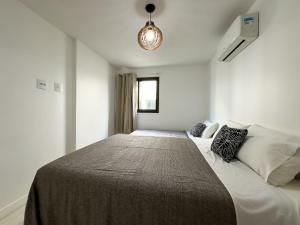 een slaapkamer met een bed met een deken erop bij Apartamentos de 2 quartos com piscina na Praia dos Anjos in Arraial do Cabo +103 foto's