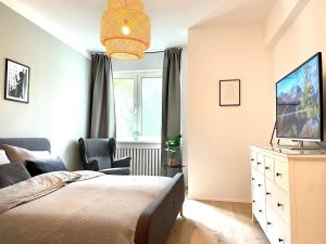 a bedroom with a bed and a tv and a chair at Apartment Rubens in Essen