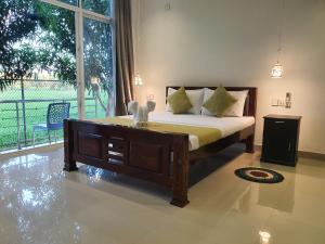 a bedroom with a bed and a large window at Villa emerald yala in Tissamaharama