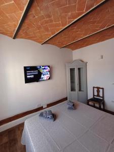 a bedroom with a bed with a tv on the wall at piccolo Garibaldi appartamento in Arezzo