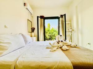 a bedroom with two swans sitting on a bed at Anemeli 2-bedroom apartment, Stoupa in Stoupa
