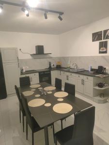 圣保罗湾城Maisonette in St Pauls Bay的厨房配有黑色的桌子和椅子 更多14张照片