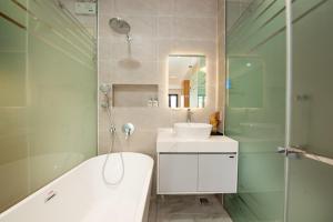 a bathroom with a tub and a sink and a mirror at Madison Urban Stay - Free Massage and Laundry in Hanoi +112 photos