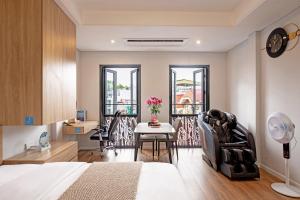 a bedroom with a bed and a table and chairs at Madison Urban Stay - Free Massage and Laundry in Hanoi