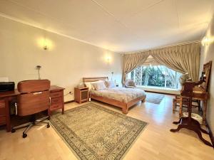 a bedroom with a bed and a desk and a window at Suburban tranquility in Johannesburg +33 photos