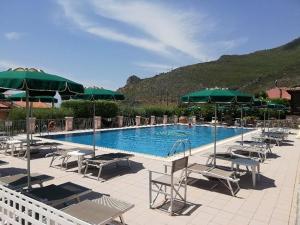 a swimming pool with chairs and umbrellas at Hotel Ristorante Borgo La Tana in Maratea