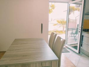 een eetkamer met een houten tafel en witte stoelen bij Active Apartments Koper in Koper