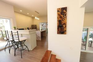 eine Küche und ein Wohnzimmer mit einer Bar und Stühlen in der Unterkunft Casa Luminiere- Keyhole Bay #5 home in Roatán