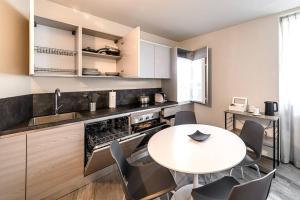 a kitchen with a table and chairs in a room at Residenza Cavour - Appartamento D in Tirano