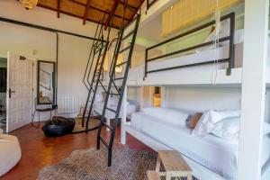 a bedroom with two bunk beds and a ladder at Karibu Lodge Boutique in Vega de San Mateo