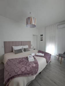 una camera da letto con un letto grande con due asciugamani sopra di ArouceHostel a Lousã