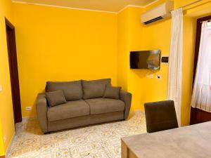 a living room with a couch and a tv at Garçonnière Casa Caterina in Ischia