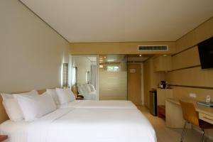 a bedroom with a large white bed and a desk at Torarica Resort in Paramaribo +14 photos