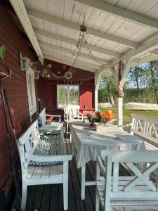 a dining room with a table and chairs on a porch at Tunnelmallinen maalaistaloelämys in Vehmaa