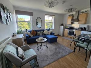 a living room with a blue couch and a kitchen at Southampton City Centre Apartment Free Private Parking in Southampton +42 photos