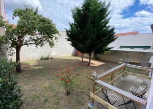 a garden with trees and red flowers and a fence at T3 Spacieux et calme in Vichy