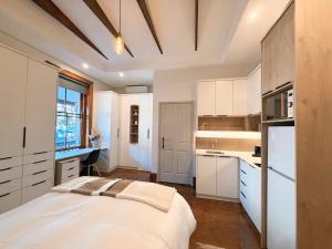 a kitchen with white cabinets and a bed in a room at Three Anchor Heart in Cape Town