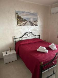 una camera da letto con un letto rosso e scarpe bianche di Vista D' Amare a Porto Potenza Picena