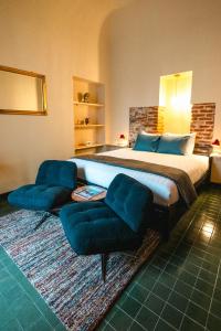 a bedroom with a large bed and two chairs at Casa Victoria in Spigno Monferrato