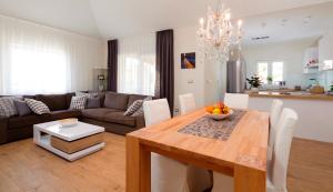 ein Esszimmer und ein Wohnzimmer mit einem Holztisch in der Unterkunft Villa Diana in Podstrana