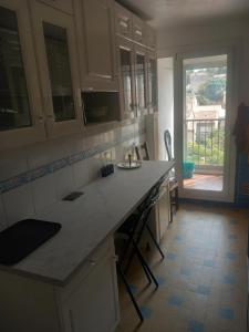 eine Küche mit einer Theke und einem großen Fenster in der Unterkunft Chambre B1 dans un appartement en colocation in Marseille