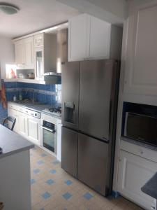 a kitchen with a stainless steel refrigerator and white cabinets at Chambre B2 dans un appartement en colocation in Marseille