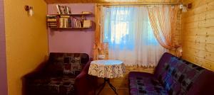 a living room with a table and a window at Domek Letniskowy nad jeziorem Głuszyńskim in Piotrków Kujawski