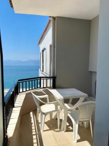a balcony with a table and chairs and the ocean at Hotel Derveni Georgiadis in Stómion +22 photos