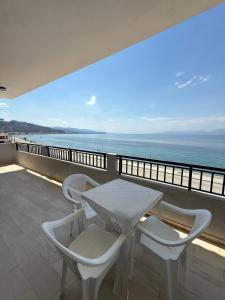 a balcony with a table and chairs and the ocean at Hotel Derveni Georgiadis in Stómion
