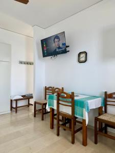 a room with a table and chairs and a tv on the wall at Hotel Derveni Georgiadis in Stómion