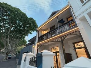 a white house with a balcony on a street at Three Anchor Heart in Cape Town