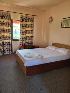 una camera da letto con un letto e una finestra con tende di Vila Roxana 2 Mai a 2 Mai