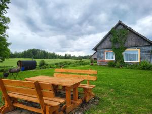 a wooden table and benches in front of a house at Marija in Krāslava