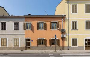 an orange building with shuttered windows on a street at 4 Bedroom Stunning Home In Crikvenica in Crikvenica