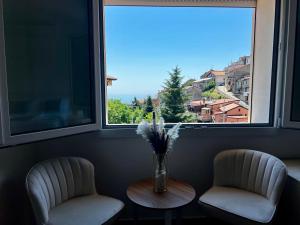 two chairs and a vase of flowers on a table in a window at B&b FONTANA GIULIA in Sersale