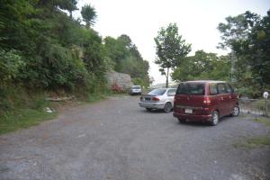 two cars parked in a gravel parking lot at Budget Rooms with Garden by Galiyat Inn Balakot in Bālākot