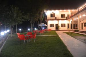 a group of chairs and tables in a yard at night at Budget Rooms with Garden by Galiyat Inn Balakot in Bālākot