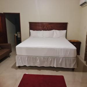 Cave HillParadise Place Grande King的卧室里有一张带木质床头板的白色大床