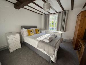 a bedroom with a bed with yellow pillows and a window at Vesna Affordable comfort in Newtown