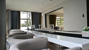 a room with a long table with chairs and a mirror at Sizanazo Guest House - in the Heart of Northcliff Hill in Johannesburg