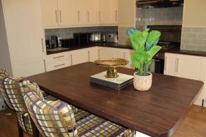 a kitchen with a wooden table with a plant on it at York Place Beautiful Apartment 5 Bedrooms Sleeps 9 in Scarborough