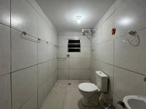 Un baño blanco con inodoro y lavabo. en Espaço Confort Próximo ao Aeroporto Guarulhos, en Guarulhos