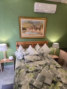 a bedroom with a bed with a picture of deer at Flower Lane Guesthouse in Kathu