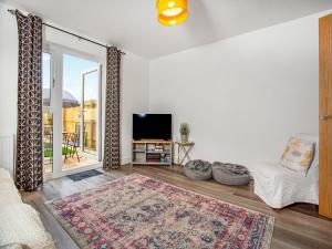 ein Wohnzimmer mit Sofa und Fernseher in der Unterkunft Wagtails in Dartmouth